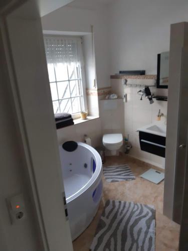 a bathroom with a tub and a sink and a toilet at Landhaus Sevenich in Münstermaifeld