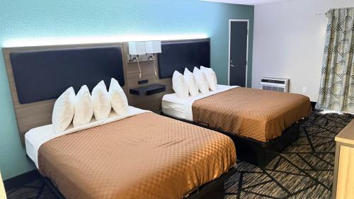 a hotel room with two beds with white pillows at Cedar Hill Lodge in Saint Ignace