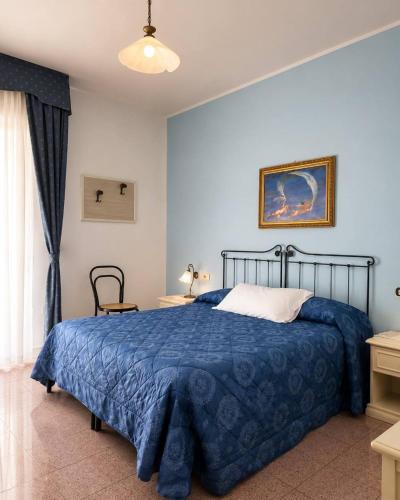 a bedroom with a blue bed with a blue blanket at Hotel Mazzocca in Caramanico Terme