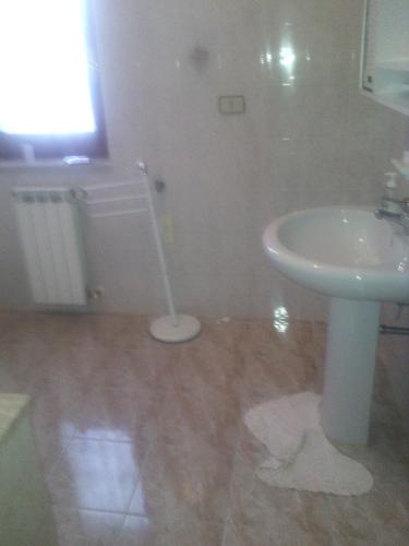 a bathroom with a white sink and a mop at B&B Bonvino in Scanzano