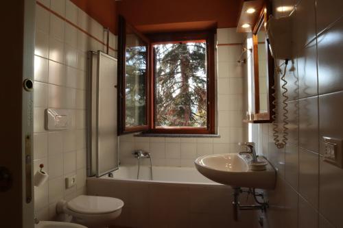 a bathroom with a sink and a tub and a toilet at Relais Cà Nova Guest House in Bogogno