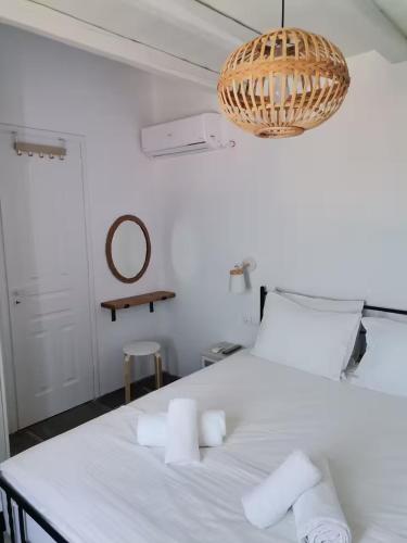a bedroom with a white bed with towels on it at Flora's House in Livadakia