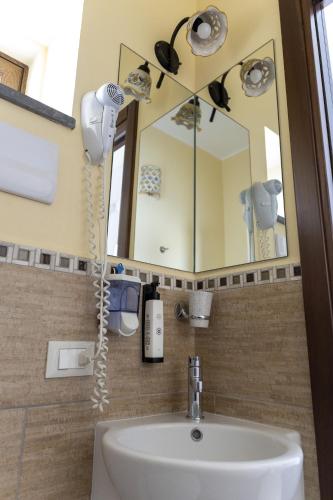 a bathroom with a sink and a mirror at Palazzo Collegiata Rooms & Suite in Monreale