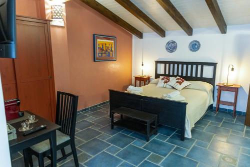 a bedroom with a bed and a table and a desk at Palazzo Collegiata Rooms & Suite in Monreale
