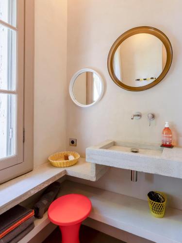 a bathroom with a red stool and a sink at Mas de charme - T2 et chambres d'hôtes avec piscine & jardin in Marsillargues