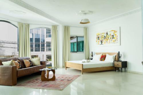 a living room with a bed and a couch at Francesca Guest House in Dakar