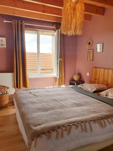 a bedroom with a large bed with a window at Gîte du Clos Giot in Saint-Vaast-la-Hougue