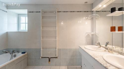 a bathroom with a towel ladder next to a sink and a tub at Eugénie in Saint-Quentin-de-Chalais