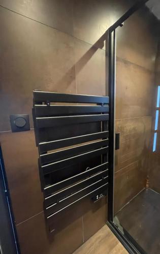 a shower with a glass door in a bathroom at La Gazolina in Boeseghem