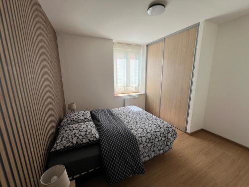 a small bedroom with a bed and a window at Escapade cosy proche nature in Saint Die