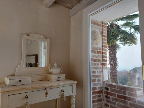 a room with a dresser with a mirror and a palm tree at Fairytale old stonehouse in Brendola