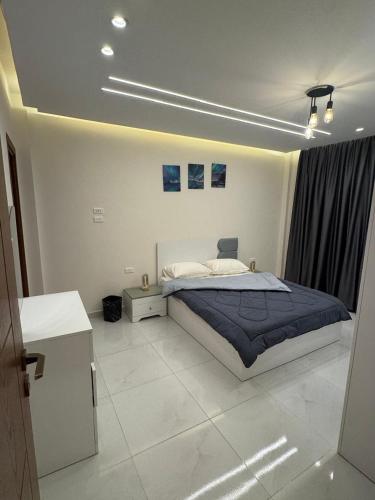 a bedroom with a large bed with a blue blanket at A Spacious, Stylish, and Perfectly Located in the heart of Cairo - Two bedroom Condo! in Cairo