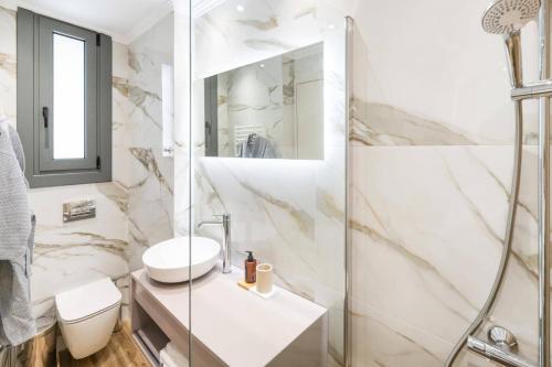 a bathroom with a shower and a toilet and a sink at Villa Cypressa by Villa Plus in Kalamitsi