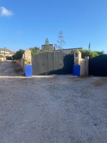 a fence with a gate in the middle of a road at Suite majorelle in Moulay Douraïne
