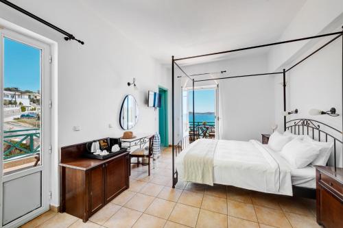 ein Schlafzimmer mit Bett, Schreibtisch und Balkon in der Unterkunft Brazzera Hotel in Finikas