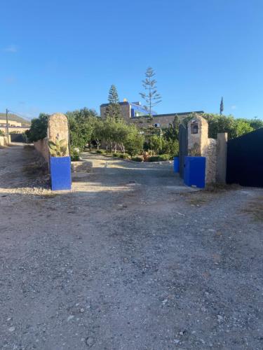 a parking lot with blue barriers in a gravel lot at Suite majorelle in Moulay Douraïne