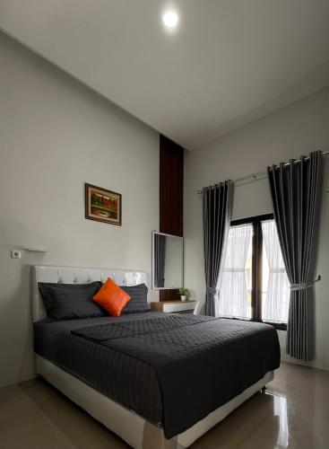 a bedroom with a large bed and a window at Villa Adela Sky Land Malang in Karangploso