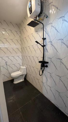 a bathroom with a toilet and a light on a wall at Villa Adela Sky Land Malang in Karangploso
