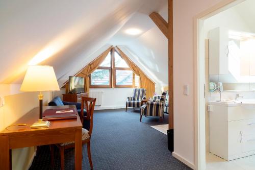 a living room with a desk and a sink and a room at Hotel am Katharinenholz in Potsdam