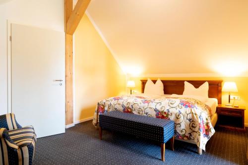 a hotel room with a bed and a chair at Hotel am Katharinenholz in Potsdam