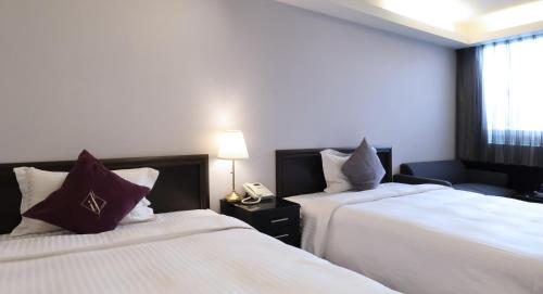 a hotel room with two beds and a telephone at 意芙旅店 Ifinn Hotel in Taipei