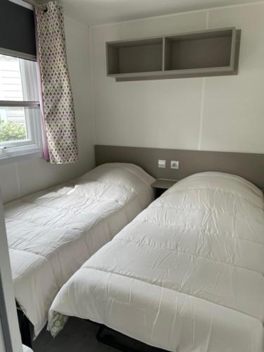 a bedroom with two beds and a window at Numero 281 in La Tremblade