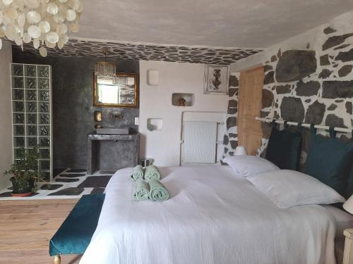 a bedroom with a large bed with two pairs of shoes on it at Lou Montadou in Yssingeaux
