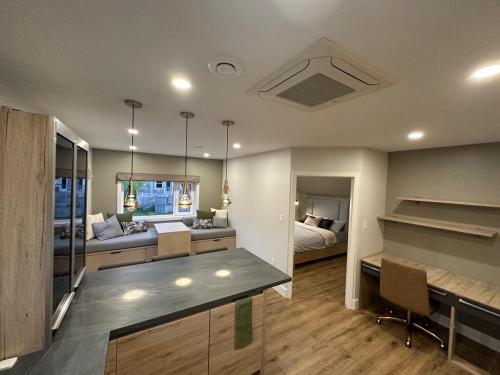 a kitchen and living room with a bed and a desk at Opulence Suite-Luxury New Build with Riverview in Montague