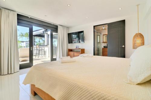 a bedroom with a large white bed and a balcony at apartement rooftop oceanfront - Hotel Aligio in Las Terrenas