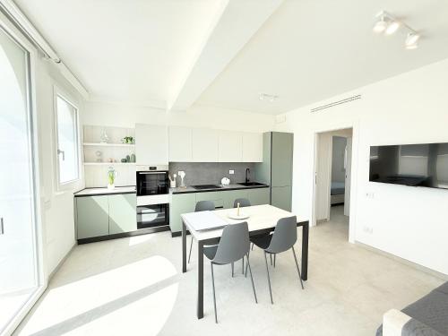 a white kitchen with a table and chairs at Conero View in Marcelli