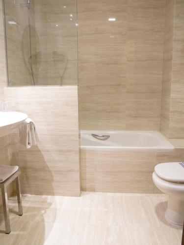 a bathroom with a tub and a toilet and a sink at UVE Alcobendas in Alcobendas