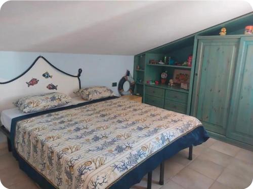 a bedroom with a bed and green cabinets at Casa Wendy in Carloforte