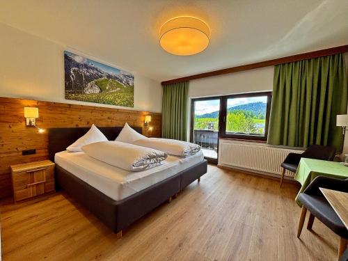 a bedroom with a large bed and a large window at Hotel Egerthof B&B in Seefeld in Tirol