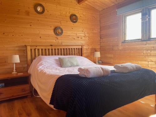 a bedroom with a bed with two towels on it at Cosy Shepherd Huts and Cabin near Newborough, Anglesey in Gaerwen