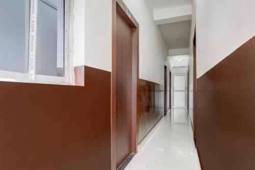 a hallway with a wooden door and a window at Hotel O Kings Hotel & Banquet in Siliguri