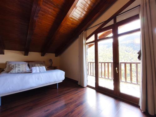 a bedroom with a bed and a large window at AC Apartaments Solana Ransol in Ransol