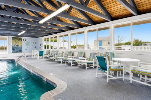 a swimming pool with chairs and a table and a table and water at Pier 7 Condominium Resort in Yarmouth