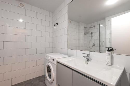 a white bathroom with a washing machine and a sink at Sella Mestia in Mestia