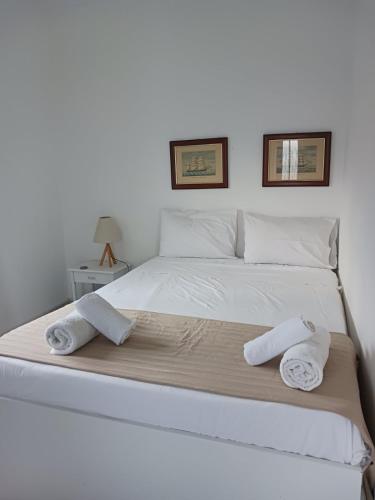 a large white bed with two towels on it at Ακροδεα in Áno Gávrion