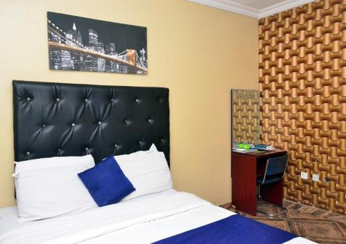 a bedroom with a bed with a black headboard at P Meridian Hotels in Awoyaya