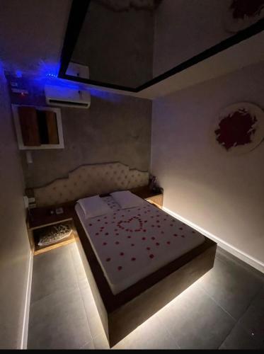 a small room with a bed with a blue light at Lemonte Motel in Brusque