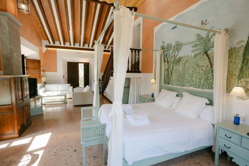 a bedroom with a canopy bed and a living room at Hotel Finca Ca N'ai - Adults Only in Sóller