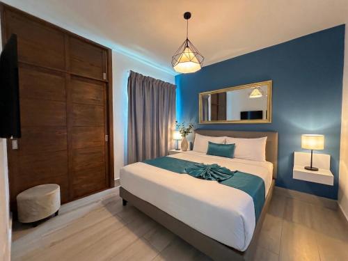a bedroom with a large bed with a blue wall at Playa Palmera Beach Resort in Punta Cana