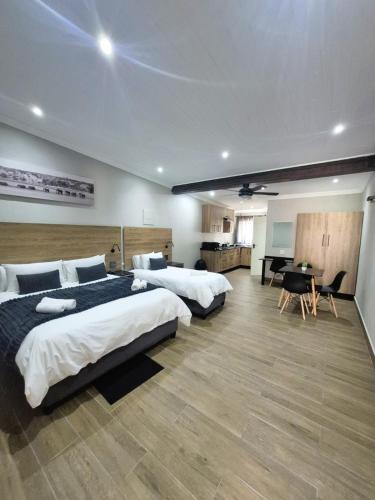 a bedroom with three beds and a desk in it at Casa Kruger Lodge in Phalaborwa