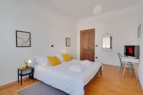 a white bed in a room with a desk at Chromatica - di fronte a Galleria Bomb in Gorizia