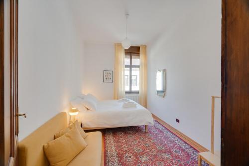 a hotel room with a bed and a couch at Chromatica - di fronte a Galleria Bomb in Gorizia