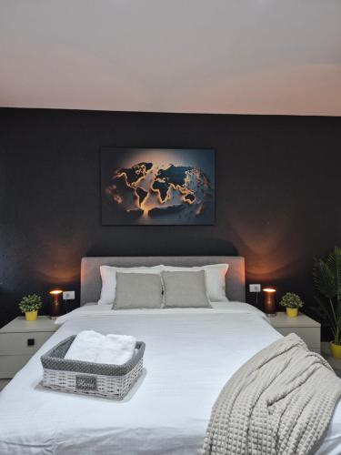 a bedroom with a large white bed with a black wall at STD AFRODITA Apartment & Garden in Vrdnik
