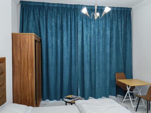 a bedroom with a bed and a blue curtain at Elegant Sea View Apartment in Ajman 