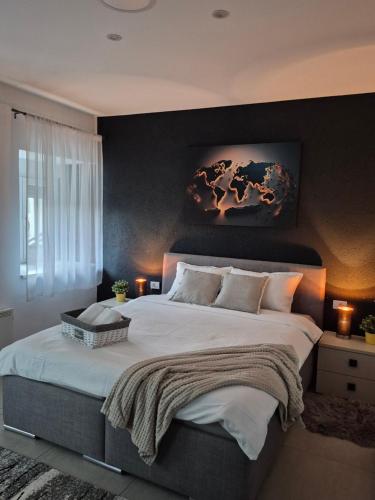 a bedroom with a large bed with a painting on the wall at STD AFRODITA Apartment & Garden in Vrdnik