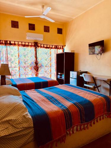 a bedroom with two beds and a desk in it at Casa Colibri La Punta in Brisas de Zicatela